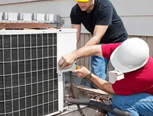 HVAC technicians repairing an outdoor AC unit on a rooftop in Lakeland, FL