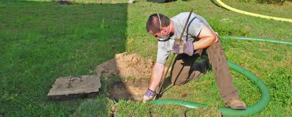 Septic pumping technician servicing a residential septic tank in Lakeland, FL