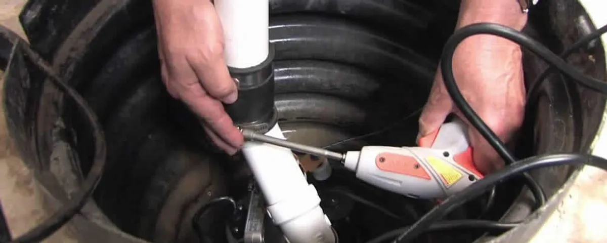 Sump pump installation technician connecting PVC discharge piping in Lakeland, FL