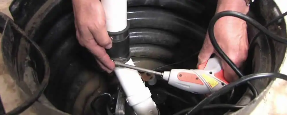 Sump pump installation technician connecting PVC discharge piping in Lakeland, FL
