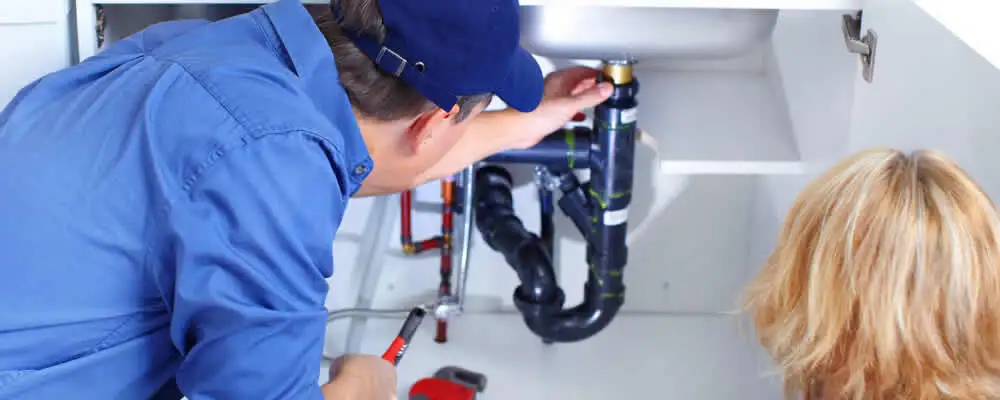 Plumber repairing under-sink drain pipes and fittings in Lakeland, FL